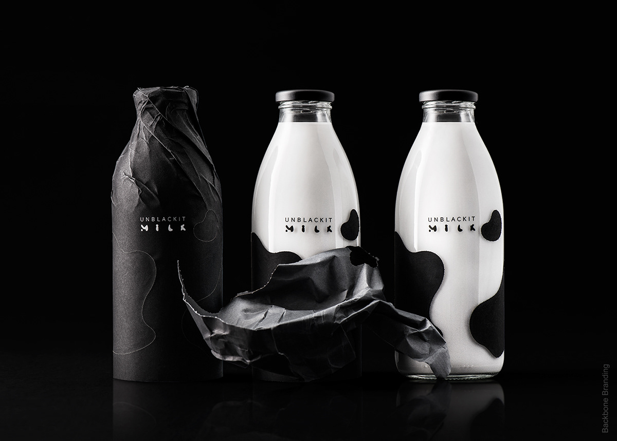 Black and white product shot of Unblackit milk bottles with cow print packaging