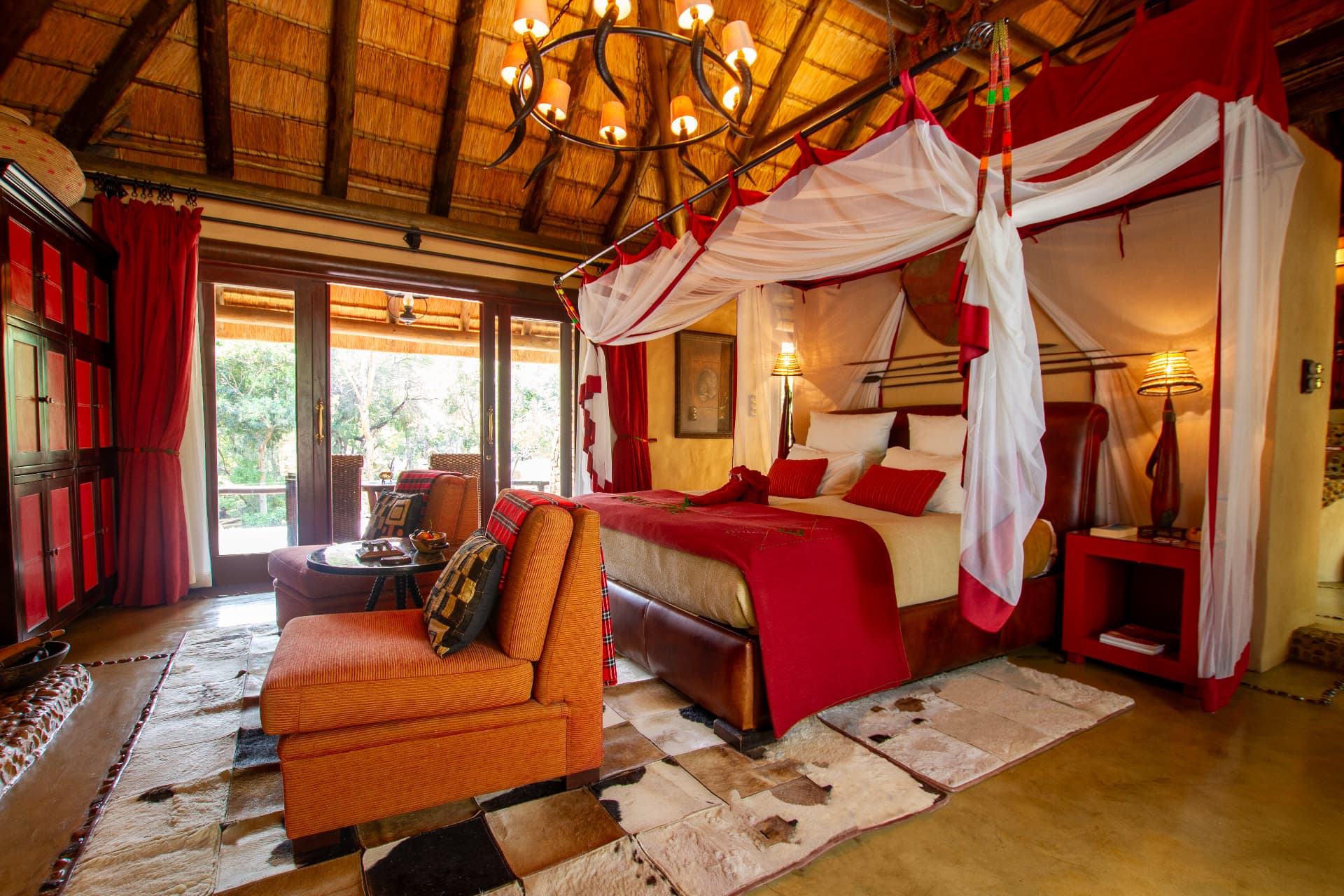 Vibrant African themed lodge suite with four poster bed and chandelier