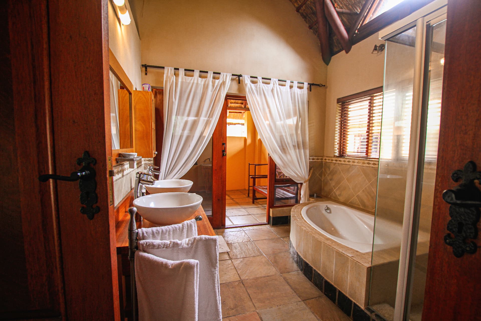 Spacious lodge bathroom with freestanding tub, double basins and natural light