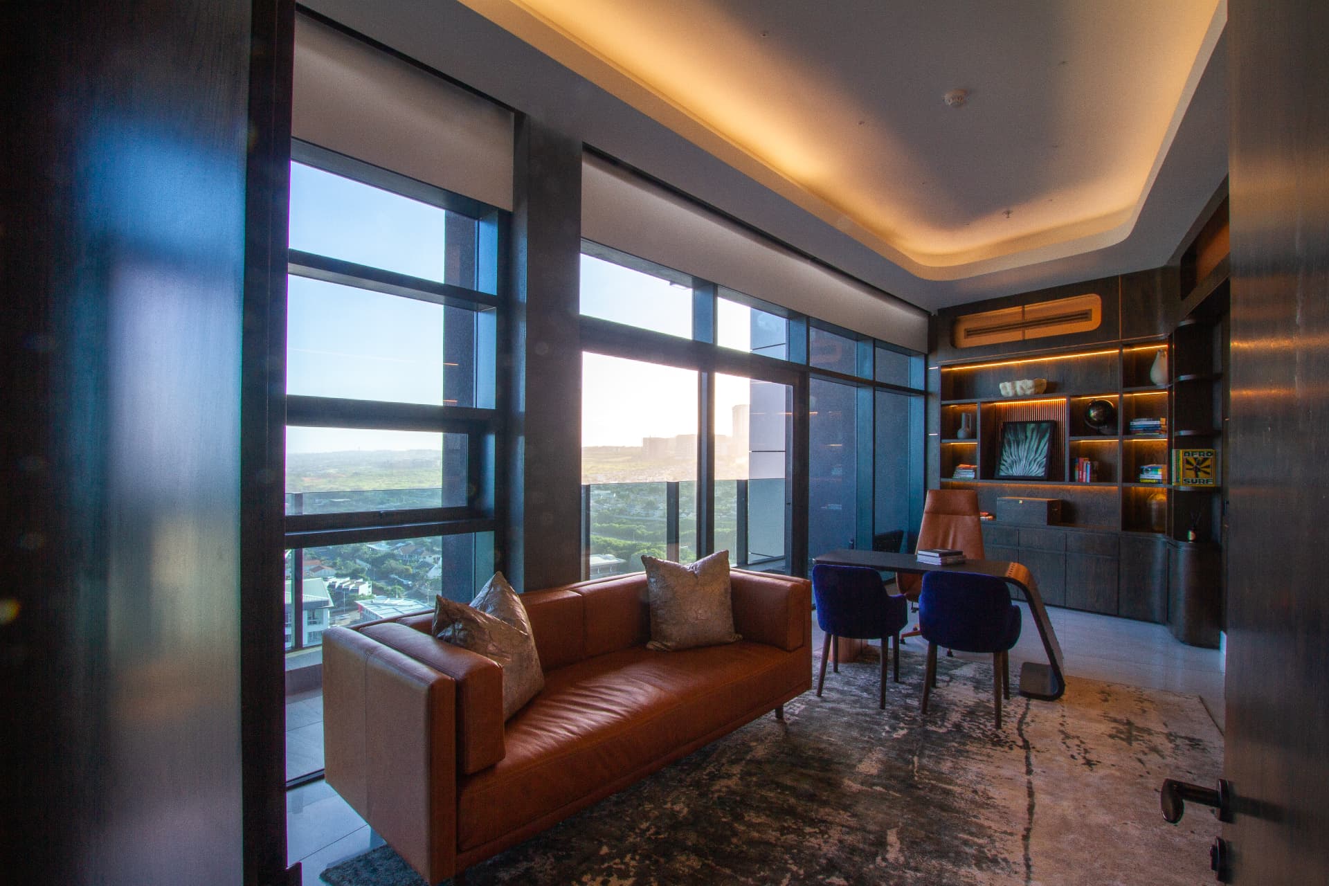 Ocean1 penthouse study with leather sofa and floor to ceiling windows